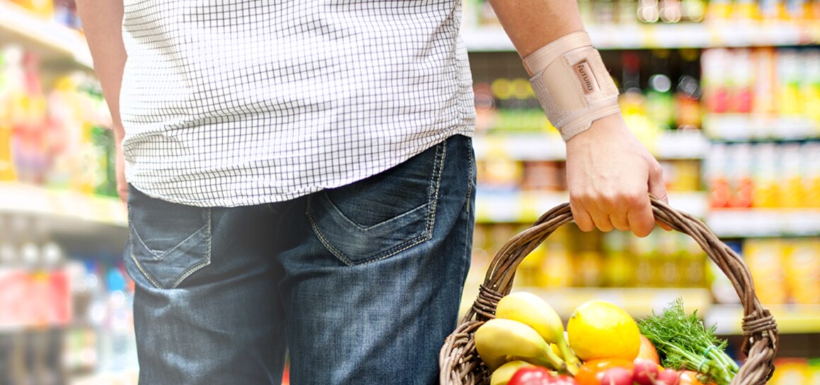 homem transporta um cesto de fruta usando um suporte de pulso