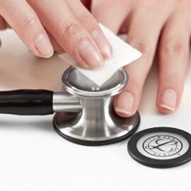 Limpeza adequada da campânula aberta de um estetoscópio Littmann utilizando um cotonete embebido em álcool.