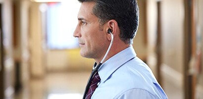 Médico a usar corretamente o seu estetoscópio Littmann, com as olivas viradas para a frente.
