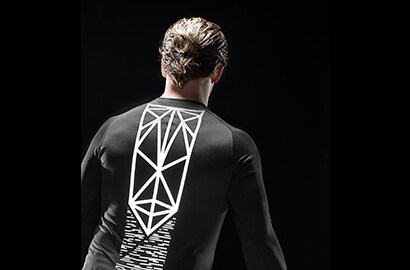 Man standing in dark wearing black shirt illuminated by 3M Scotchlite Black Stretch Reflective.
