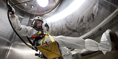 Um trabalhador em fato de proteção num espaço confinado
