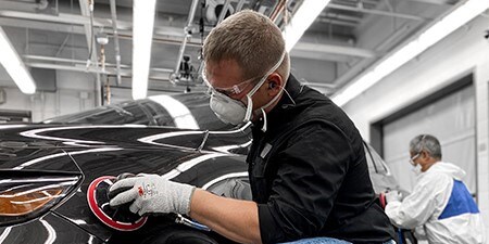 Imagem mostrando um homem usando abrasivos premium com ferramentas premium em um carro para alcançar excelentes resultados.
