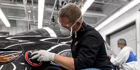 Imagem mostrando um homem usando abrasivos premium com ferramentas premium em um carro para obter resultados excelentes.
