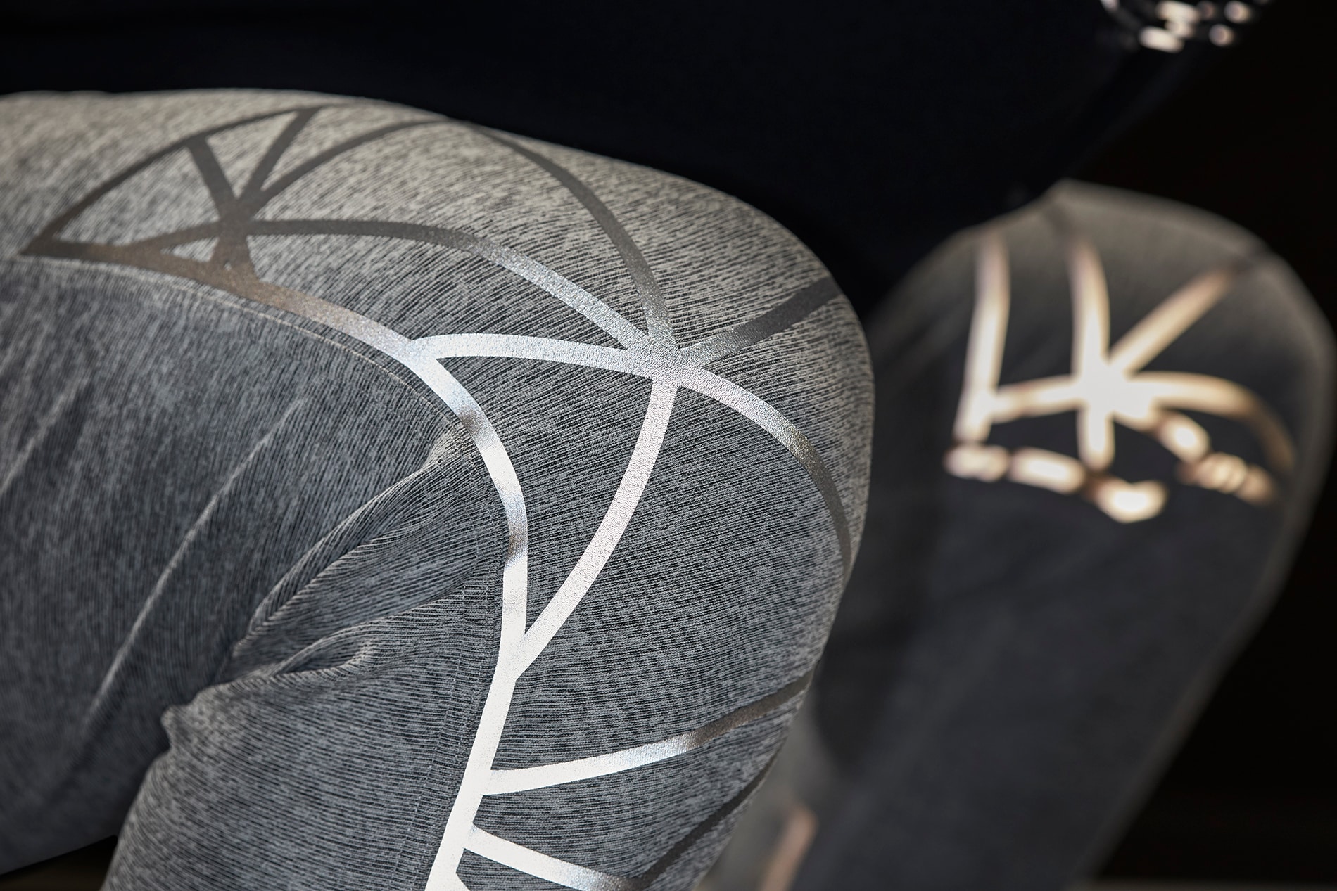 Close-up of illuminated 3M Scotchlite Black Stretch Reflective stretching over knees of activewear pants.
