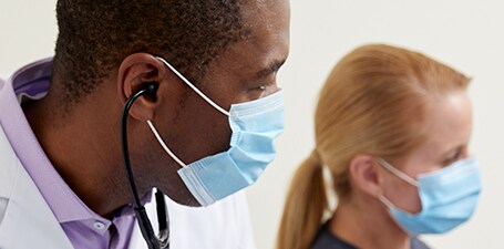 Grande plano do médico com o estetoscópio nos ouvidos
