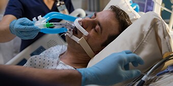 doente em cuidados intensivos a ser tratado por pessoal médico
