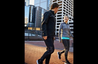 Man and woman in city walking, talking, exercising with 3M Scotchlite C790 Carbon Black Stretch Reflective Material.
