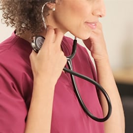 Enfermeira a colocar as olivas do seu Estetoscópio 3M Littmann Classic III nos ouvidos.