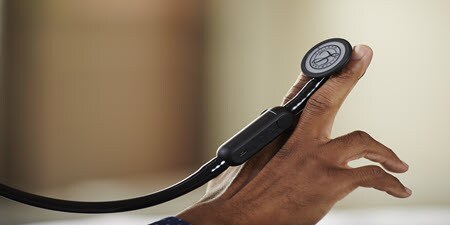 Grande plano de um estetoscópio Littmann CORE Digital sobre os dedos de alguém.
